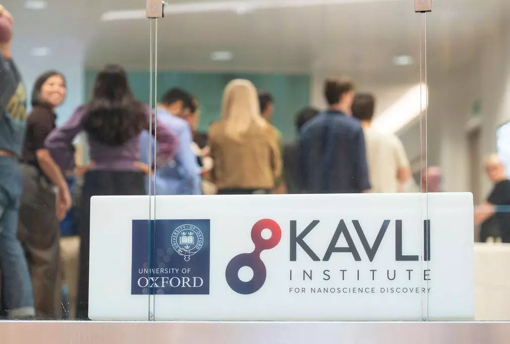 Lightbox showing the Kavli Institute for Nanoscience Discovery and University of Oxford logos in the foreground, symposium delegates in the background